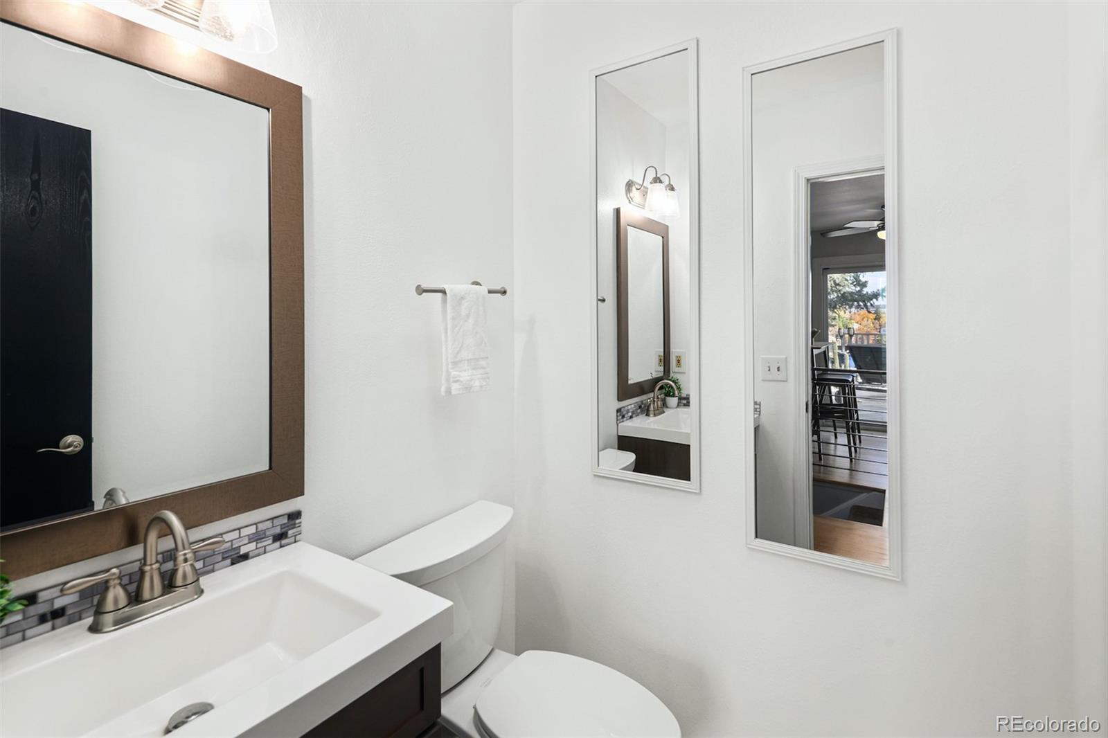 10499 Newcombe Street Westminster, CO 80021 - Photo 18 of 33 a bathroom with a sink vanity mirror and toilet