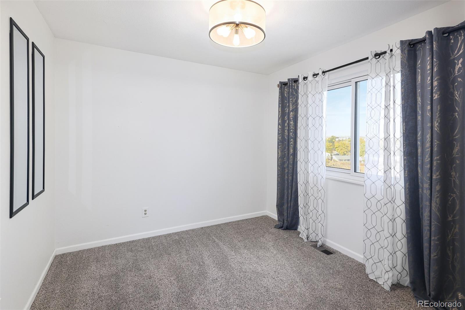 10499 Newcombe Street Westminster, CO 80021 - Photo 22 of 33 a view of an empty room with a window