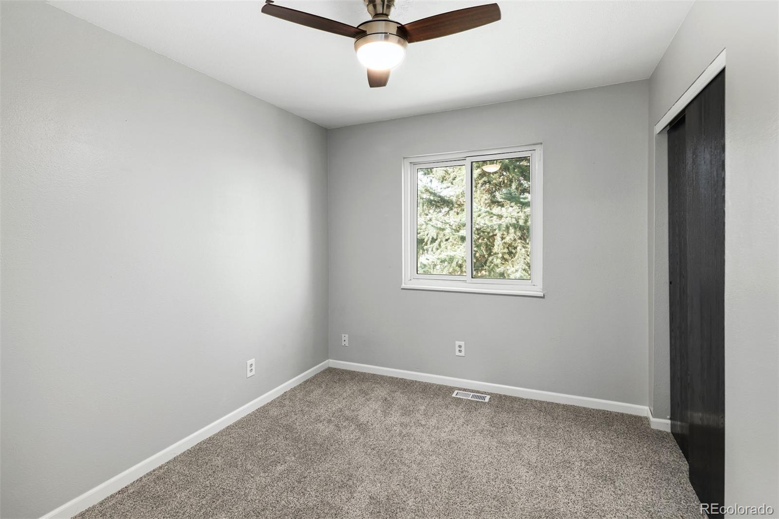 10499 Newcombe Street Westminster, CO 80021 - Photo 25 of 33 an empty room with windows and ceiling fan