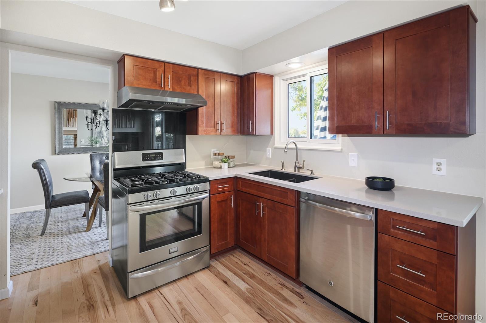 10499 Newcombe Street Westminster, CO 80021 - Photo 4 of 33 a kitchen with stainless steel appliances a stove a sink and a microwave