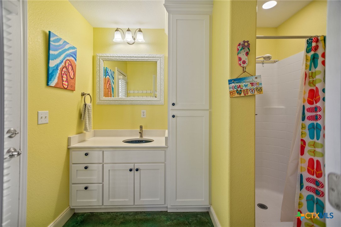 23 Macey Street Port O'Connor, TX 77982 - Photo 16 of 47 a bathroom with a sink a mirror and a shower