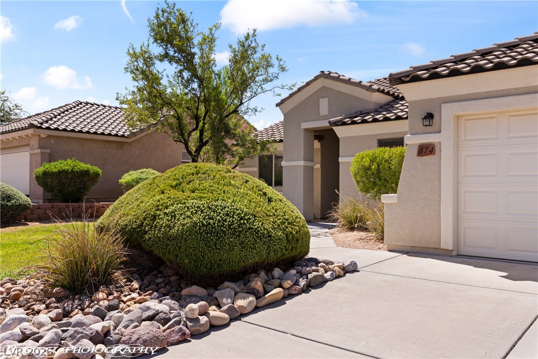 874 Glendale Road Mesquite, NV 89027 - Photo 9 of 71 Mediterranean-inspired architecture graces this inviting residence, featuring a tile roof and meticulously maintained landscaping.