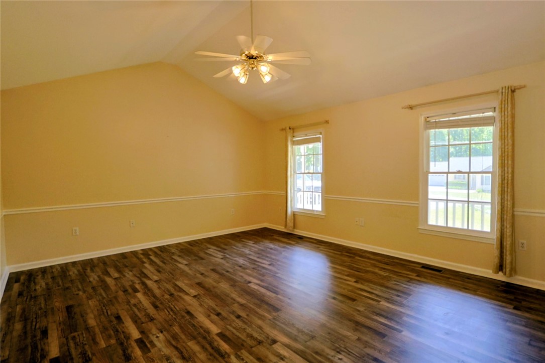 This spacious room features vaulted ceilings and rich wood flooring, ideal for a peaceful retreat.