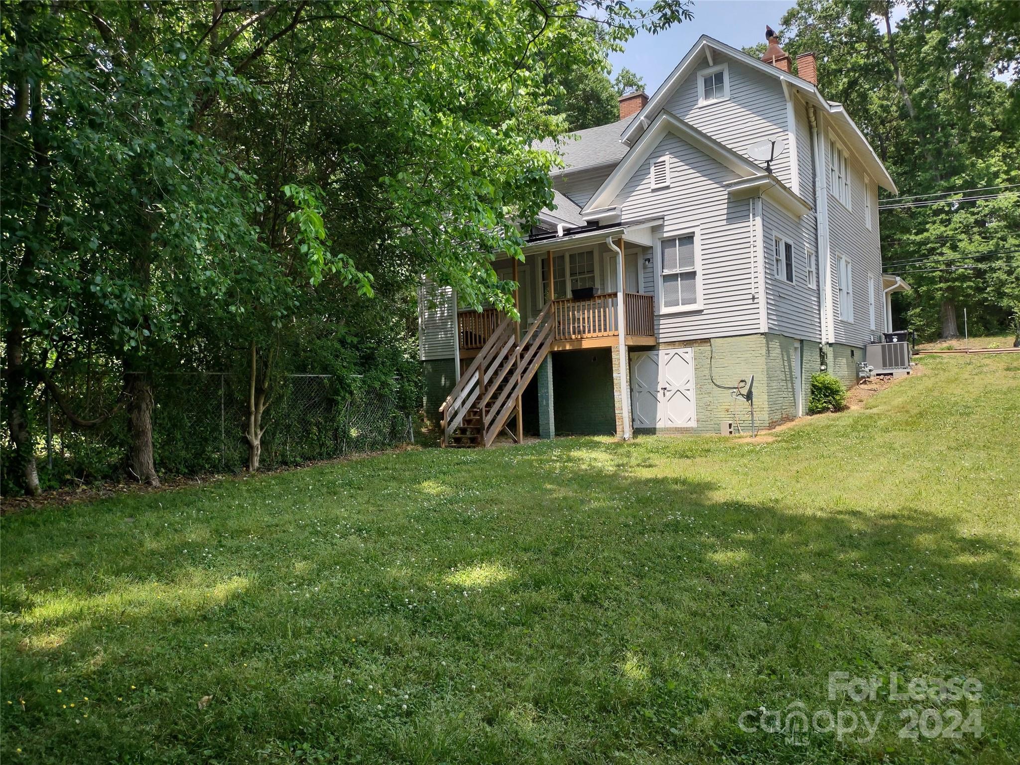 476 Spring Street Southwest Concord, NC 28025 - Photo 11 of 12 a view of a house with a big yard and large trees