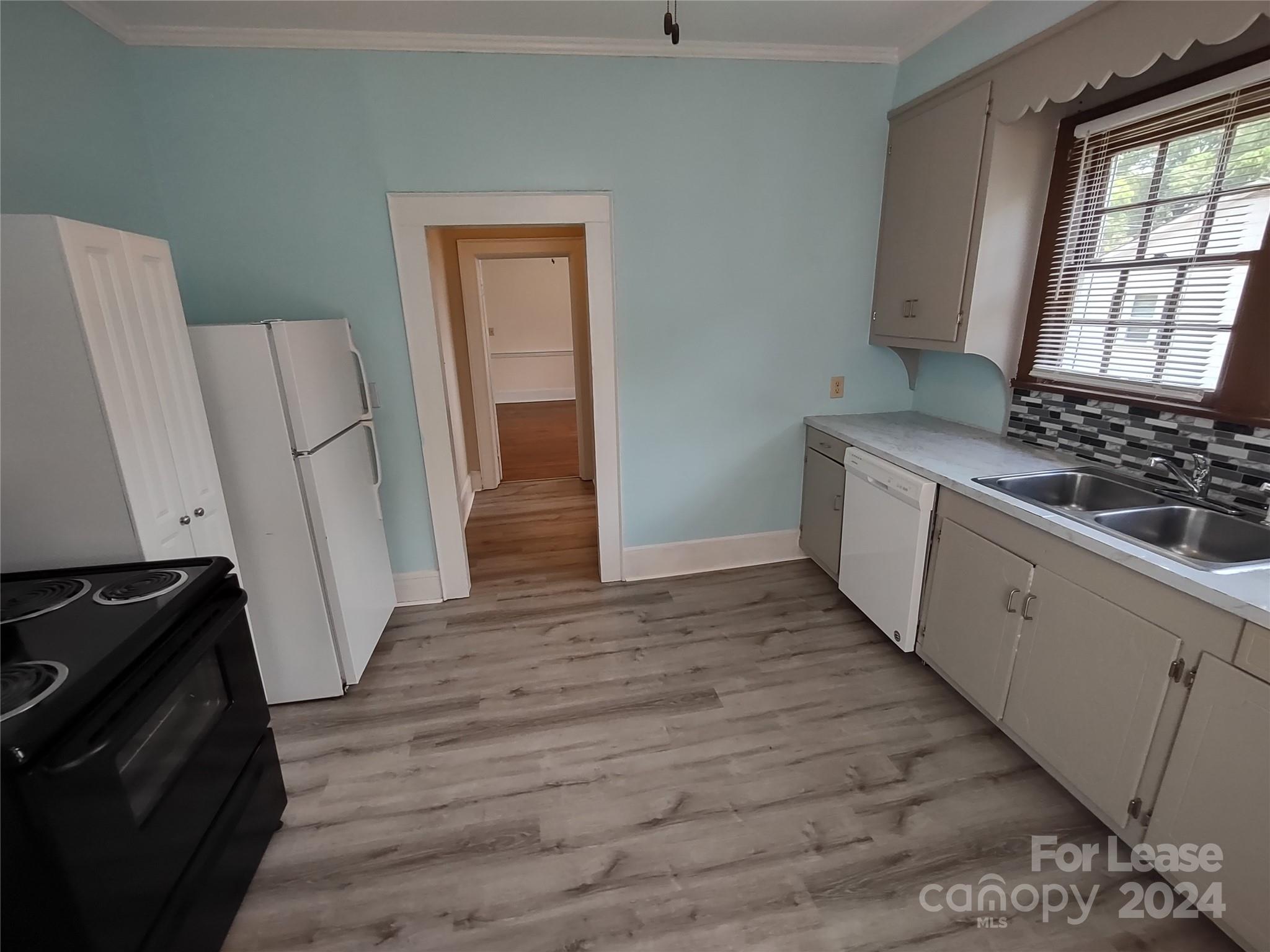 476 Spring Street Southwest Concord, NC 28025 - Photo 3 of 12 a view of an empty room with wooden floor and a stove