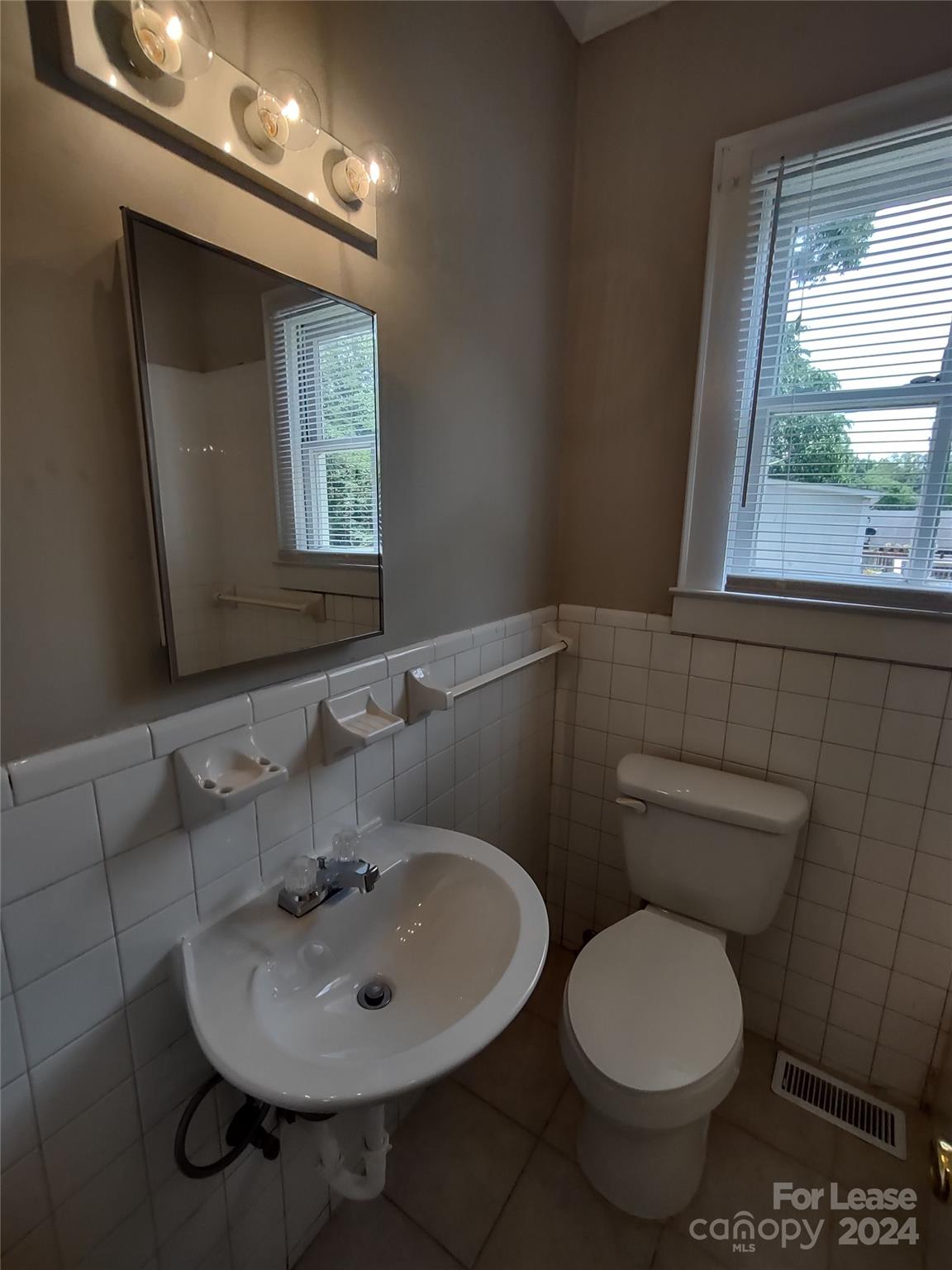 476 Spring Street Southwest Concord, NC 28025 - Photo 4 of 12 a bathroom with a toilet sink and mirror