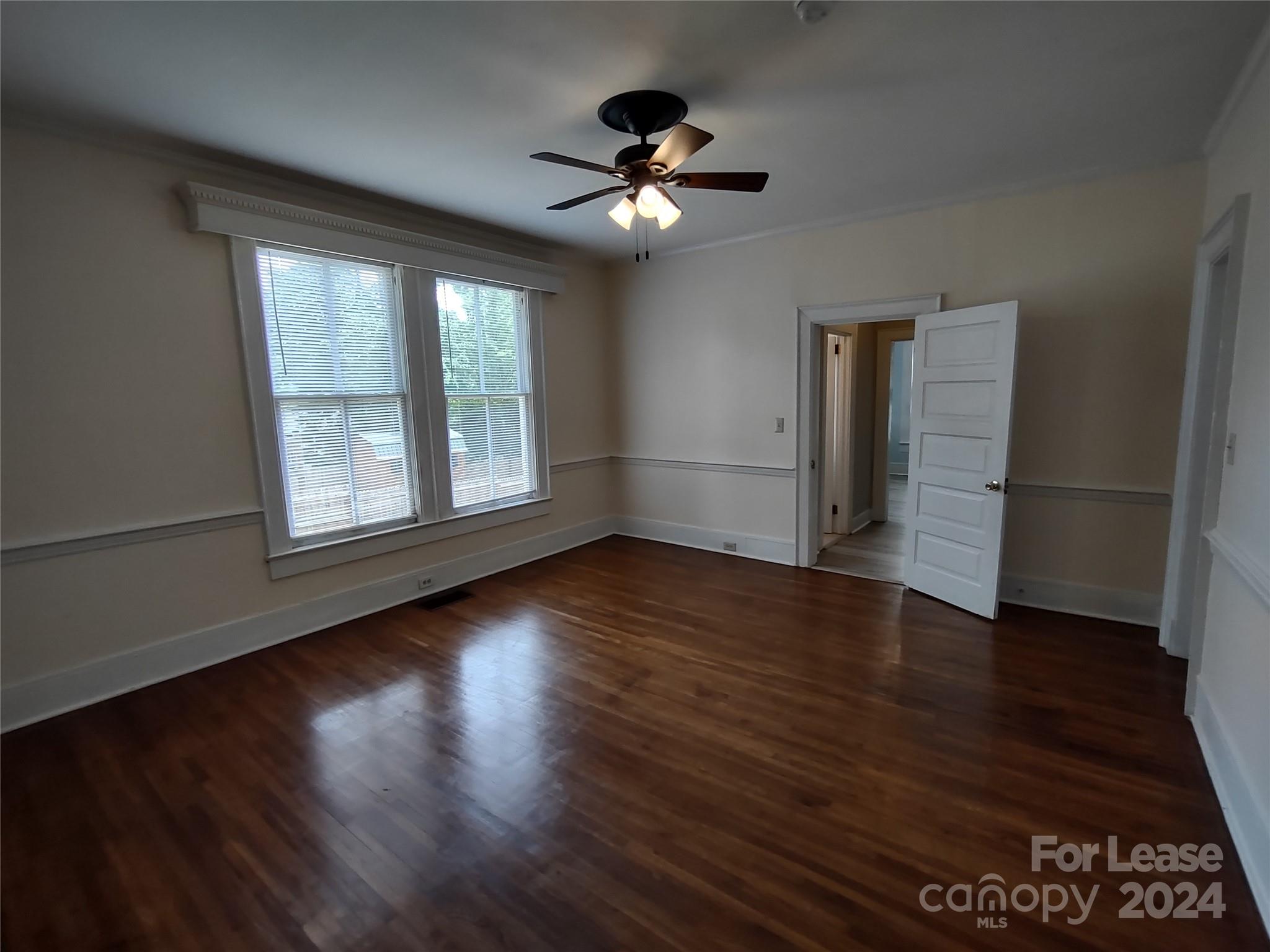 476 Spring Street Southwest Concord, NC 28025 - Photo 6 of 12 a view of an empty room with wooden floor and a window