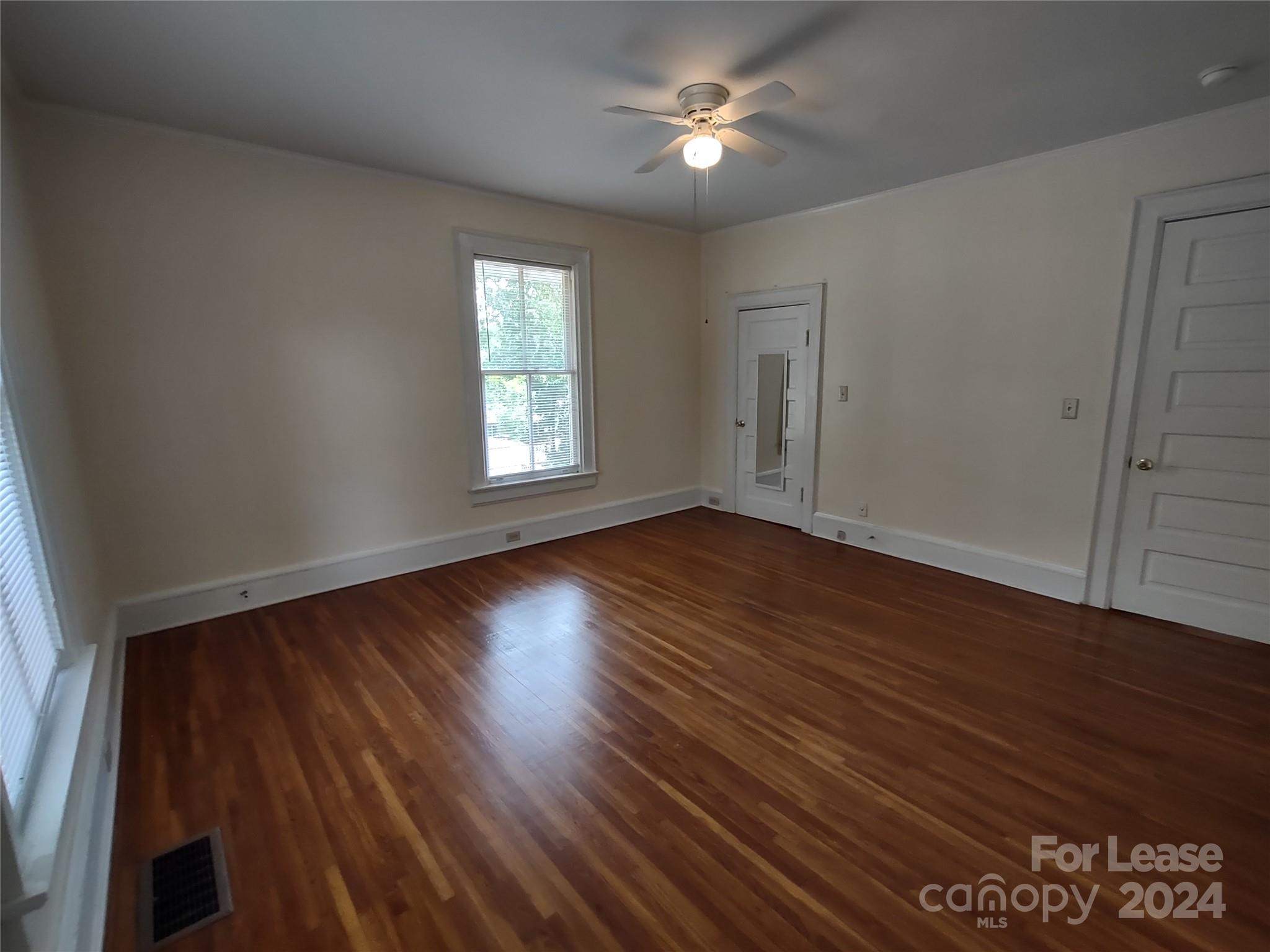 476 Spring Street Southwest Concord, NC 28025 - Photo 8 of 12 a view of empty room with wooden floor and fan