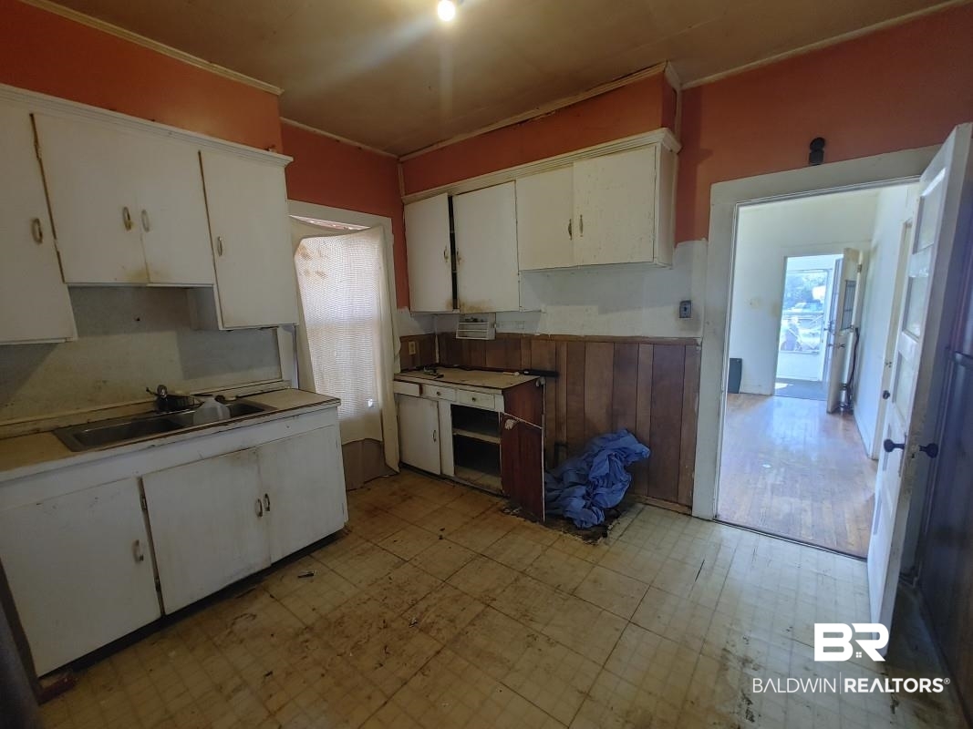 1706 Lomeroy Street Mobile, AL 36604 - Photo 20 of 24 Kitchen featuring light floors, white cabinetry, light countertops, and a sink