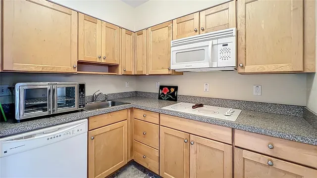 a kitchen with stainless steel appliances granite countertop a refrigerator a sink a stove and white cabinets