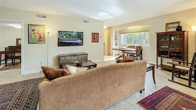 a living room with furniture a flat screen tv and a table