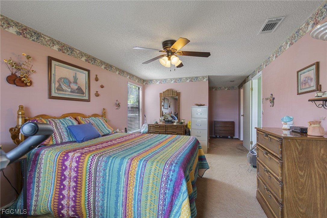 4496 31st Avenue Southwest Naples, FL 34116 - Photo 11 of 26 a bedroom with bed and a chandelier