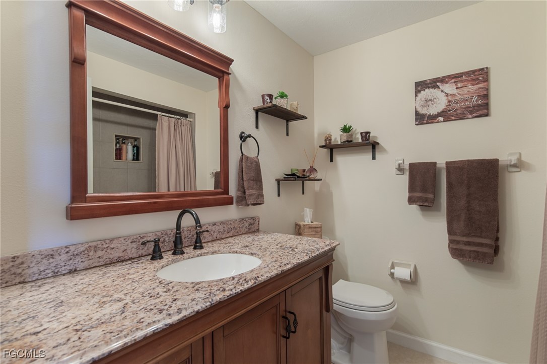 4496 31st Avenue Southwest Naples, FL 34116 - Photo 13 of 26 a bathroom with a granite countertop sink vanity mirror and toilet