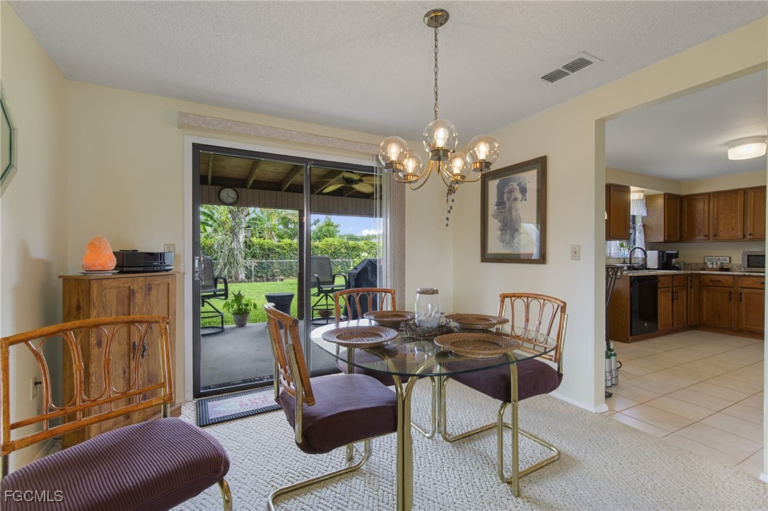 4496 31st Avenue Southwest Naples, FL 34116 - Photo 5 of 26 a dining room with furniture a chandelier and window