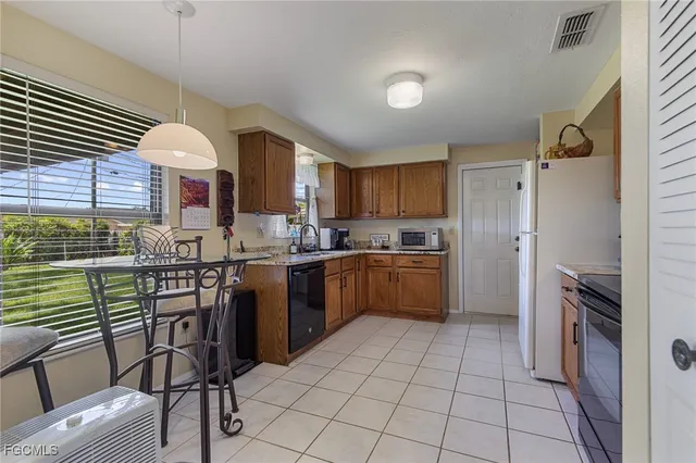 a kitchen with a sink window and stainless steel appliances