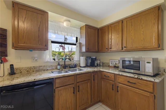a kitchen with stainless steel appliances granite countertop a sink a stove and cabinets