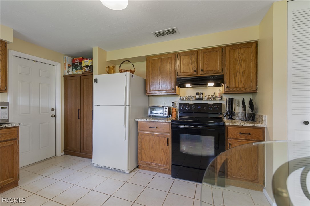 4496 31st Avenue Southwest Naples, FL 34116 - Photo 8 of 26 a kitchen with a refrigerator and a stove top oven