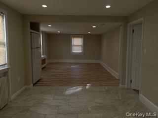 89 2nd Street, Unit 1 New Rochelle, NY 10801 - Photo 8 of 13 Empty room with recessed lighting and radiator