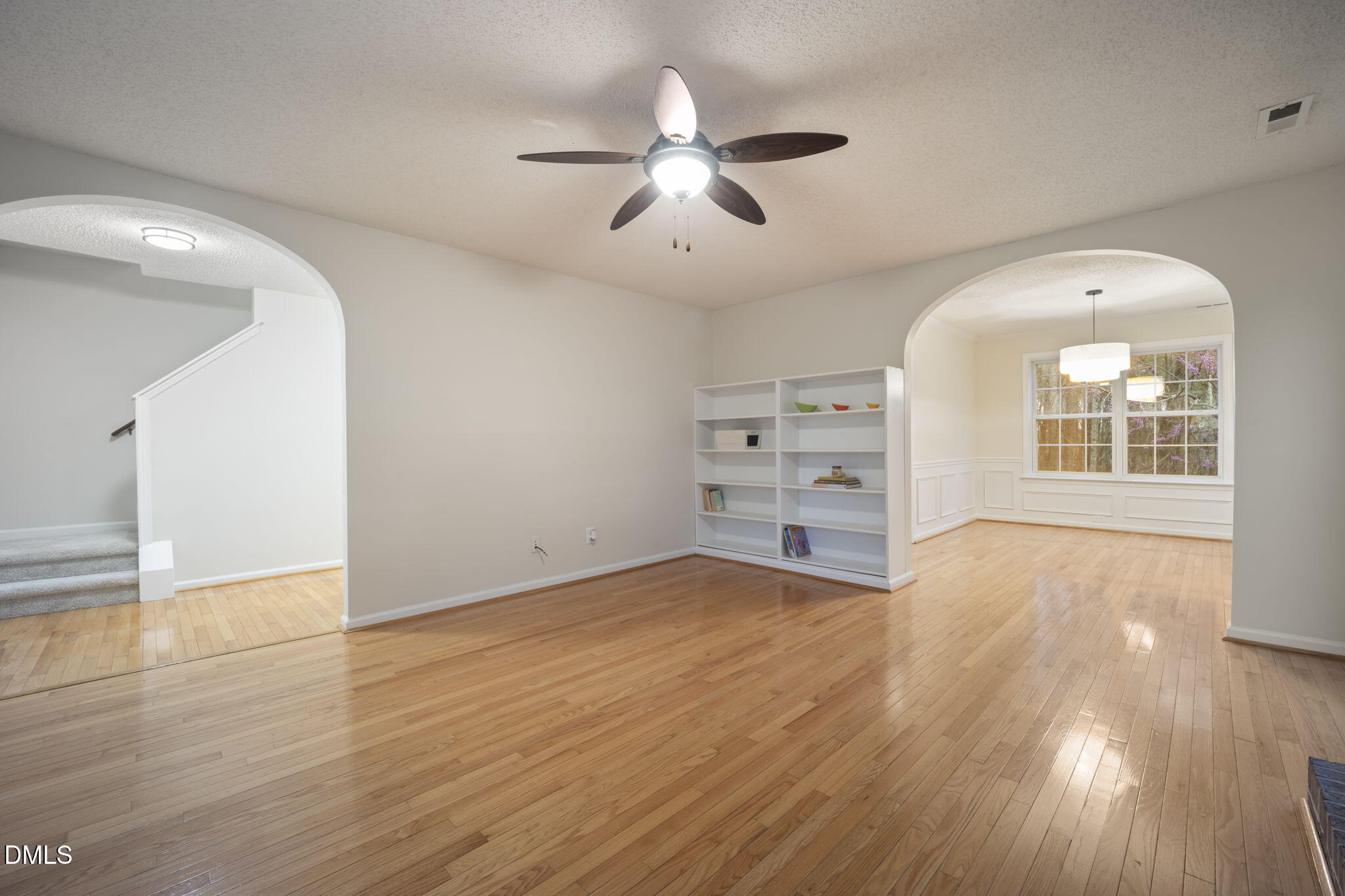 900 Spring Meadow Drive Durham, NC 27713 - Photo 3 of 26 an empty room with wooden floor chandelier and windows