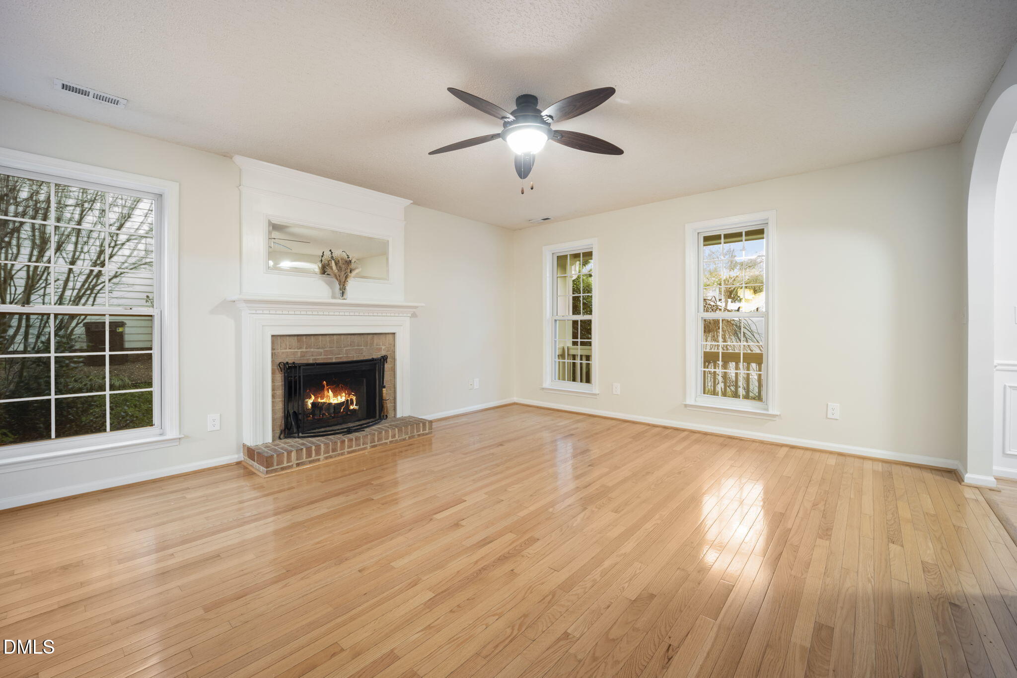 900 Spring Meadow Drive Durham, NC 27713 - Photo 4 of 26 an empty room with windows fireplace and wooden floor