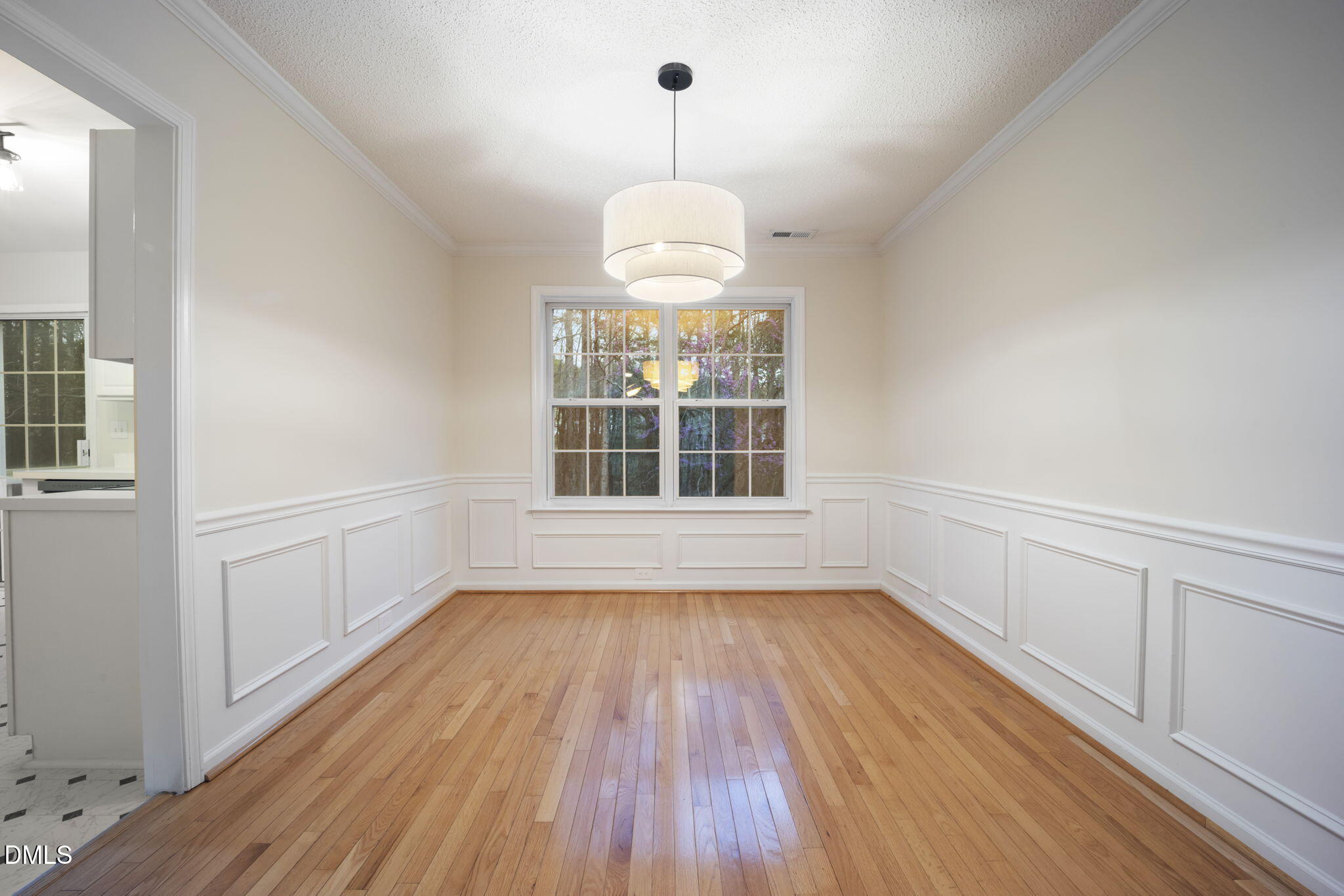 900 Spring Meadow Drive Durham, NC 27713 - Photo 5 of 26 a view of an empty room with wooden floor and a window