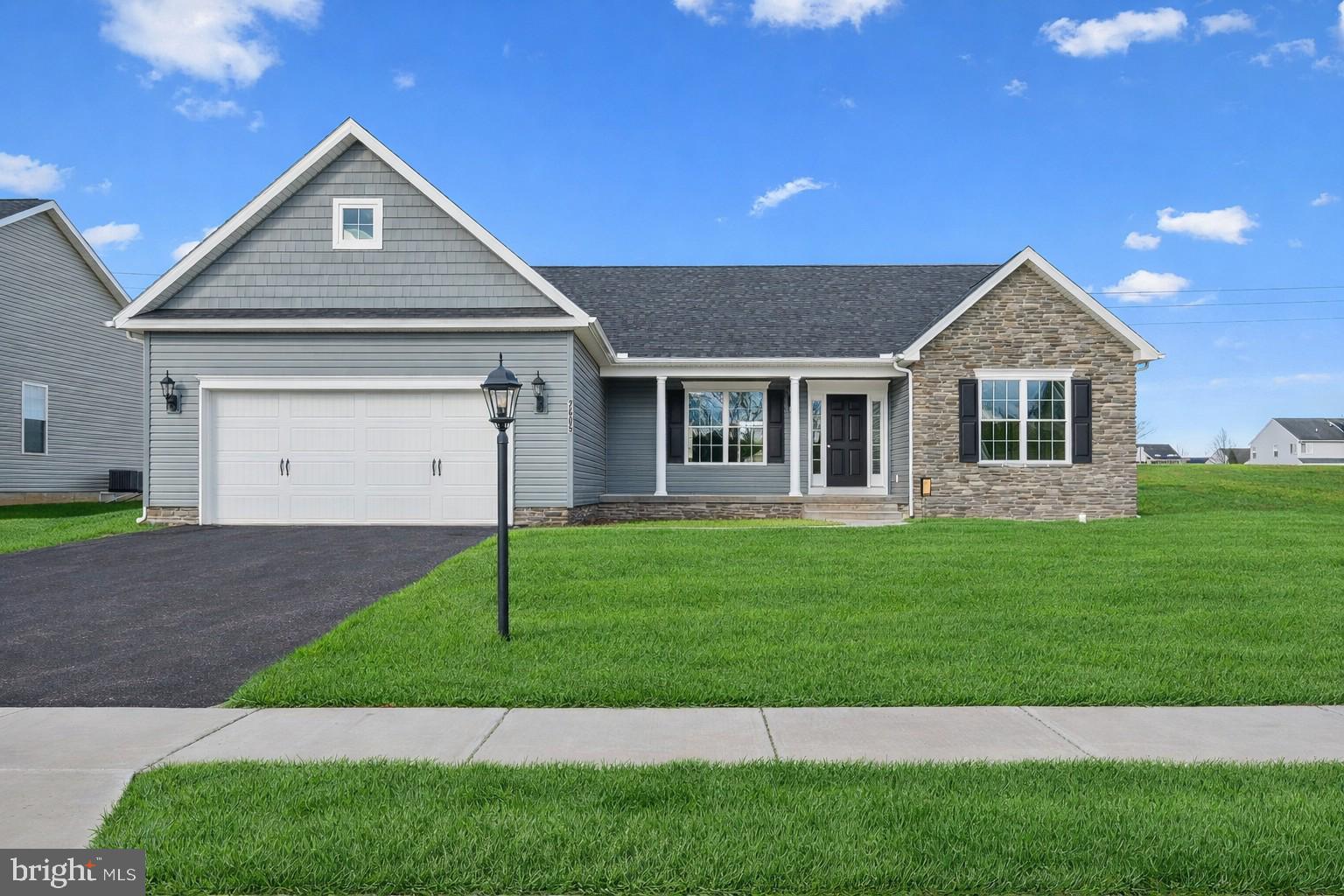 a front view of a house with a garden and yard