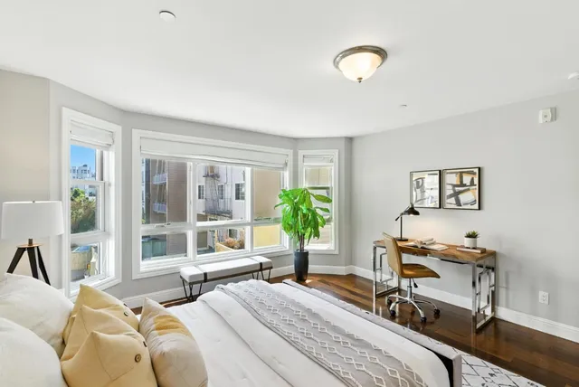 a bedroom with a bed and a large window