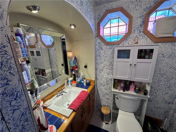 a bathroom with a toilet a sink and a mirror