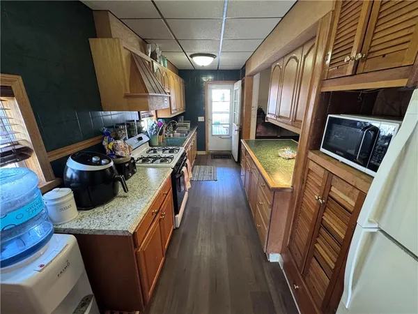 a kitchen with stainless steel appliances granite countertop a sink a stove microwave and cabinets