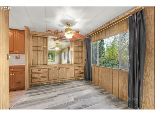 a view of a hallway with wooden floor and cabinet