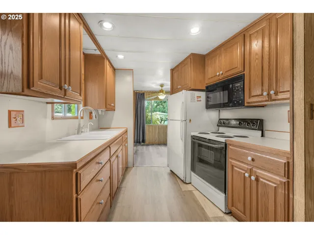 a kitchen with stainless steel appliances granite countertop a sink a stove and a refrigerator