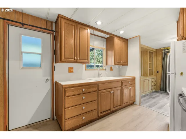 a kitchen with a refrigerator sink and cabinets