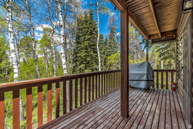 11237 East Aspen Road, Unit 74 Heber City, UT 84032 - Photo 12 of 32 Spacious exterior deck with wood flooring, wood railing, and a tongue-and-groove wood ceiling, surrounded by mature trees