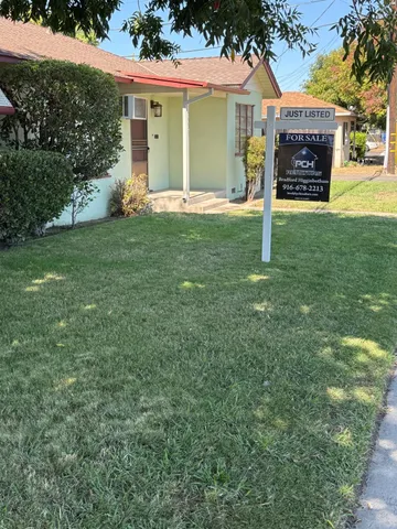 a view of a house with a yard and a garage