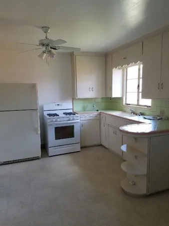 a kitchen with a sink cabinets appliances and a window