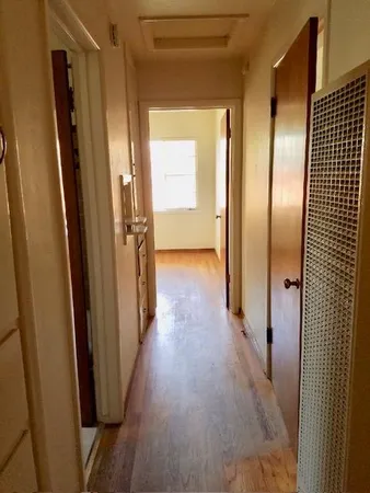 a view of a hallway with wooden floor