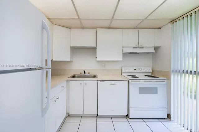 a kitchen with cabinets appliances and a sink