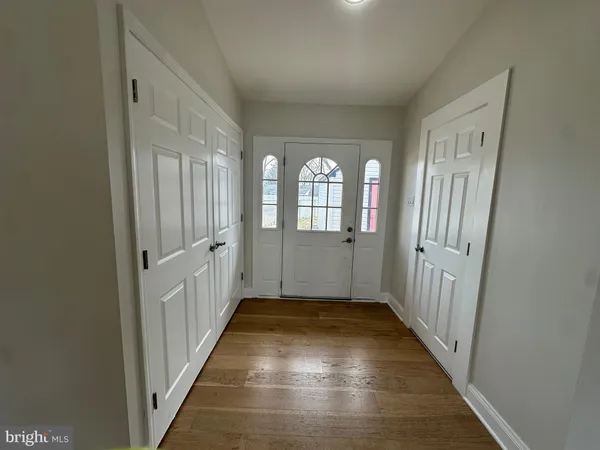 a view of a hallway with wooden floor and windows