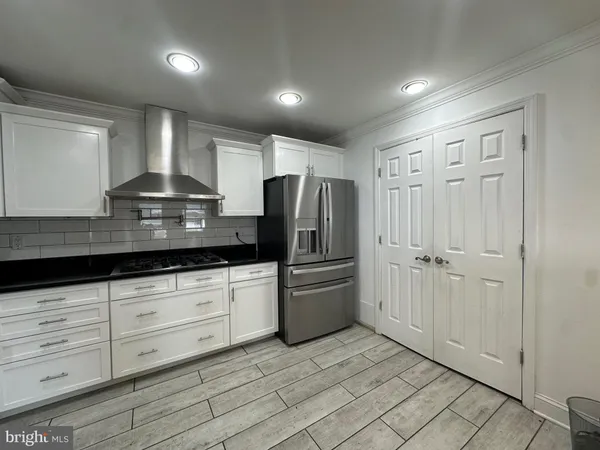 a kitchen with stainless steel appliances granite countertop a refrigerator and a stove top oven