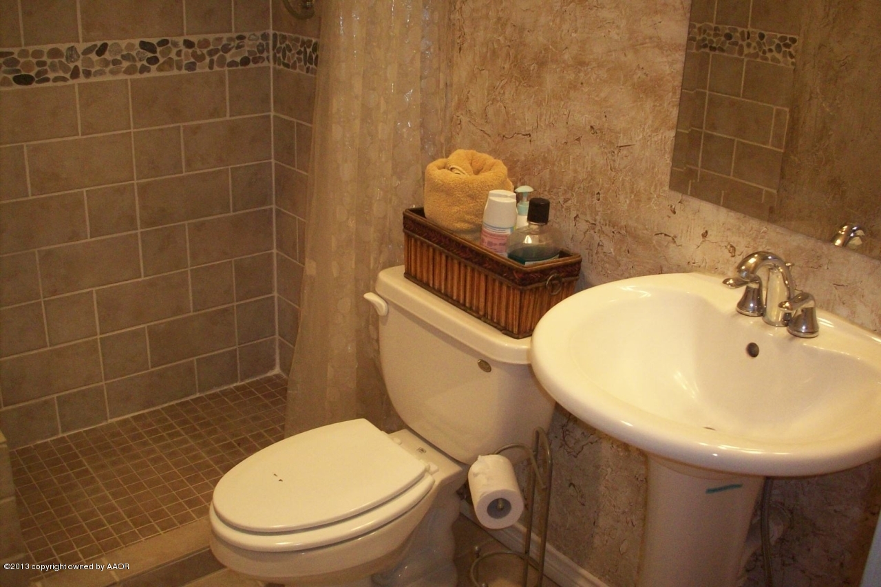 4203 Relatta Avenue Amarillo, TX 79110 - Photo 20 of 24 a bathroom with a sink a toilet and a mirror