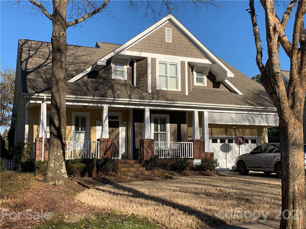 a view of a white house with large windows next to a road