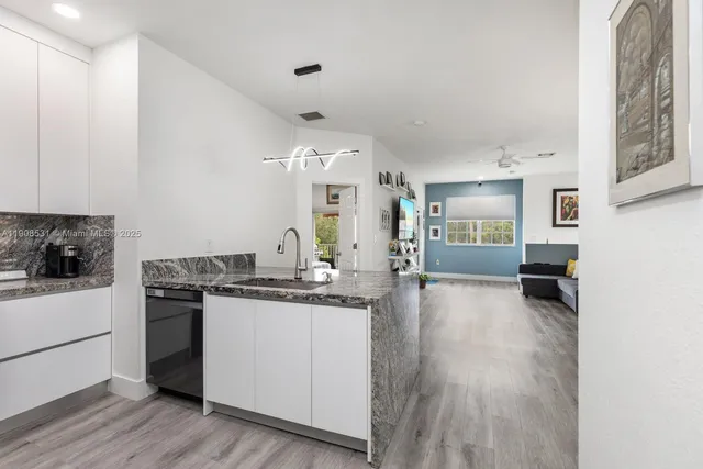 a kitchen with granite countertop a stove a sink dishwasher and a refrigerator