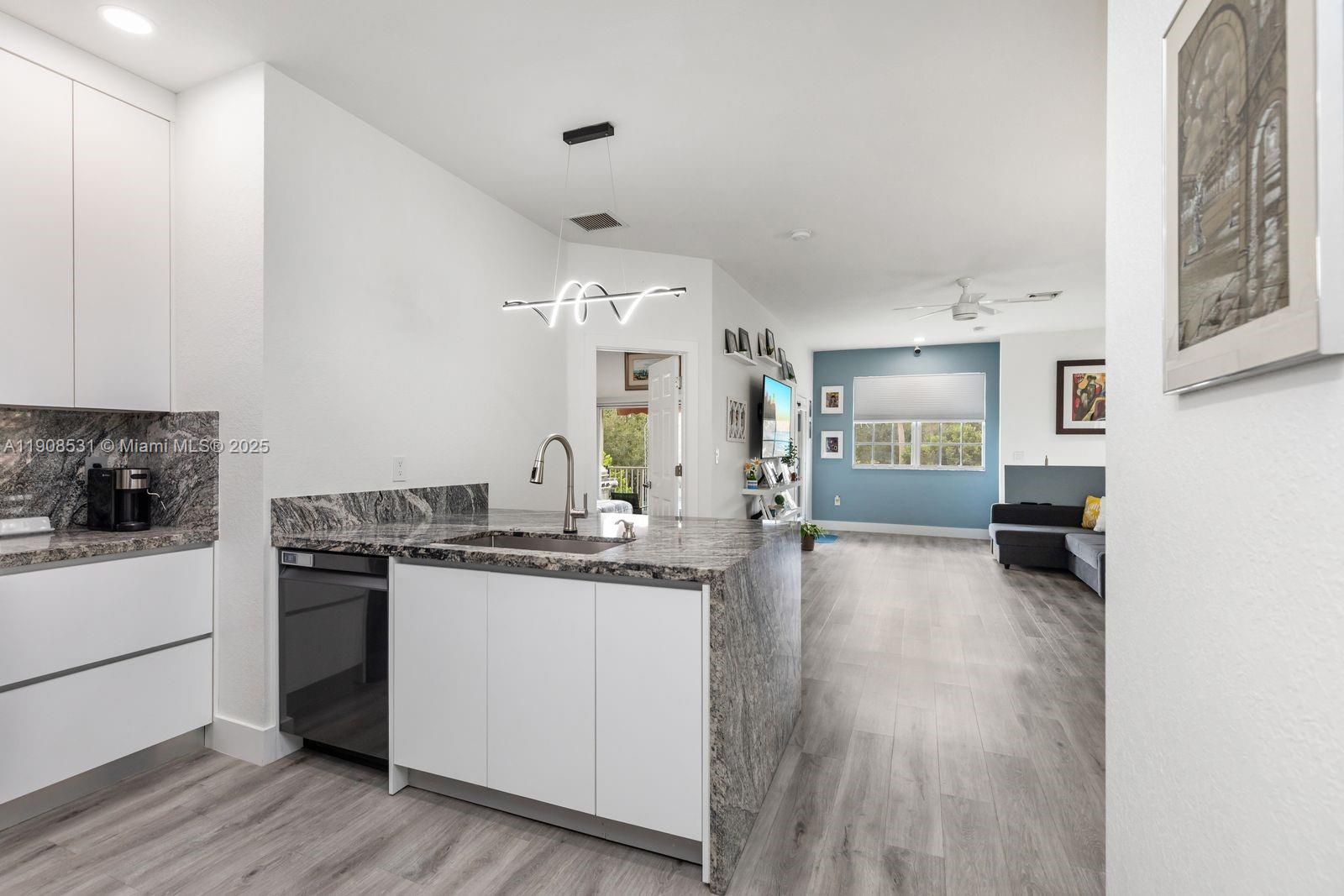13216 Southwest 44th Street, Unit 11204 Miramar, FL 33027 - Photo 20 of 48 a kitchen with granite countertop a stove a sink dishwasher and a refrigerator