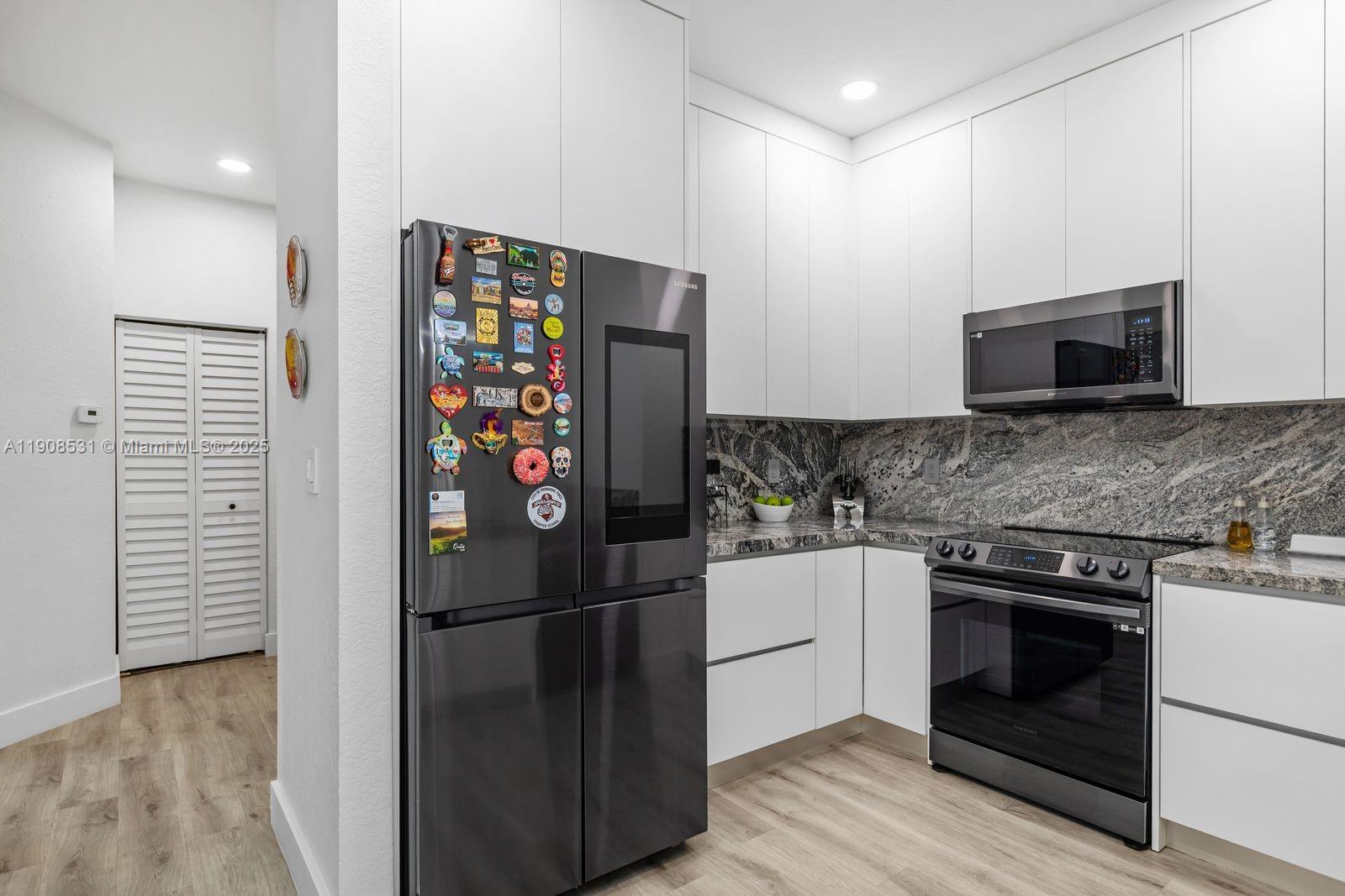13216 Southwest 44th Street, Unit 11204 Miramar, FL 33027 - Photo 22 of 48 a kitchen with stainless steel appliances granite countertop a refrigerator and a stove top oven