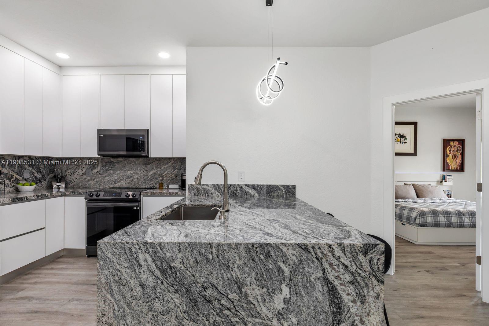 13216 Southwest 44th Street, Unit 11204 Miramar, FL 33027 - Photo 24 of 48 a bedroom with a bed and wooden floor