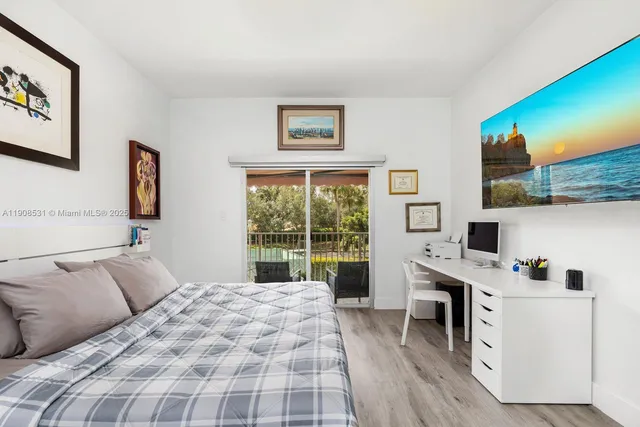 a bedroom with a bed and a flat tv screen on the dresser
