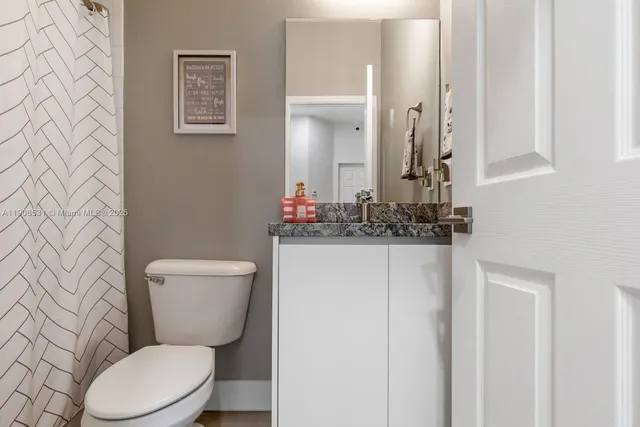 a white toilet sitting next to a bathroom sink