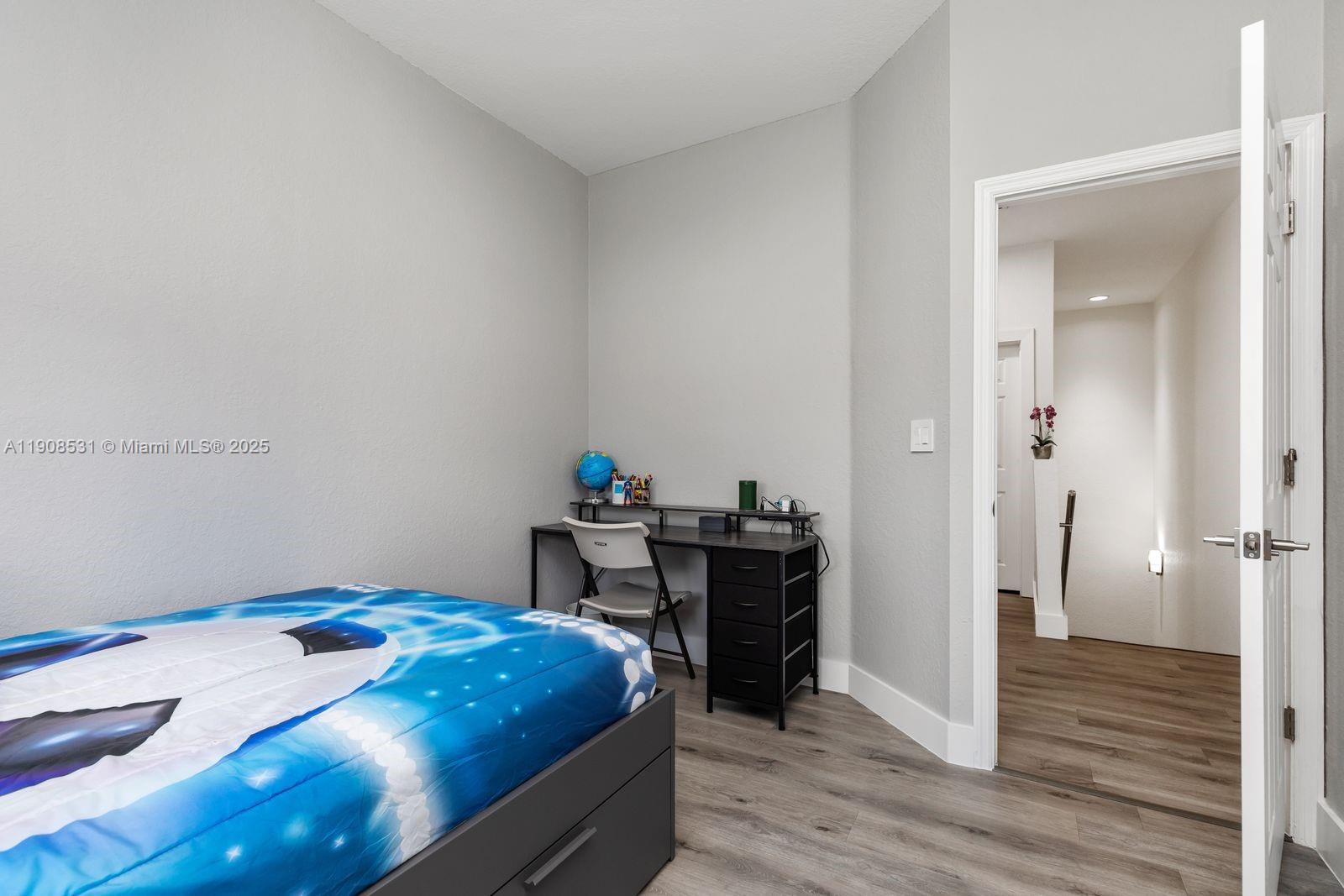 13216 Southwest 44th Street, Unit 11204 Miramar, FL 33027 - Photo 42 of 48 a bedroom with a bed and wooden floor