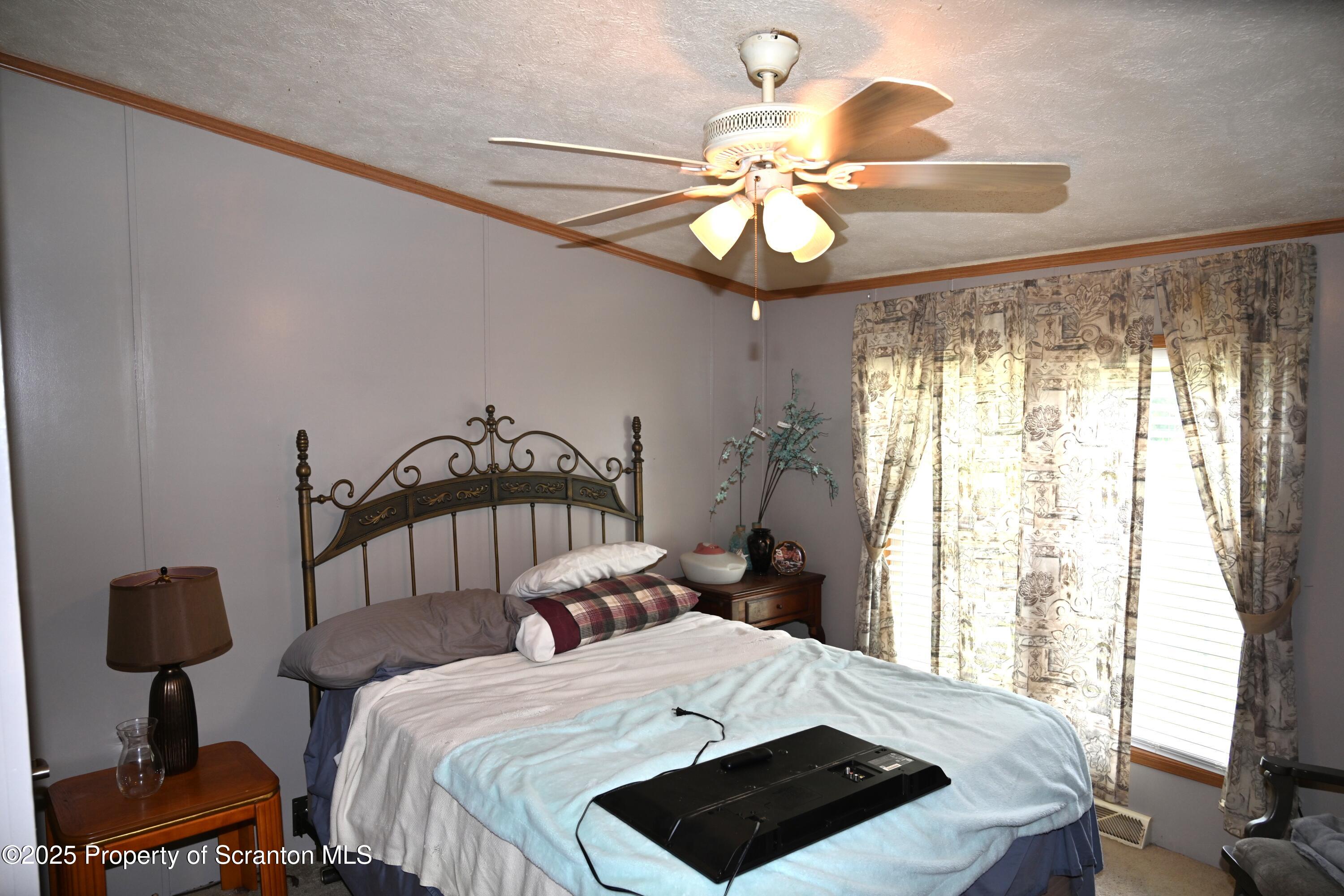 26930 Highway 11 Great Bend, PA 18821 - Photo 19 of 53 a bedroom with a bed and a chandelier
