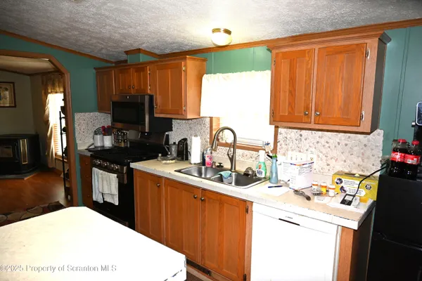 a kitchen with a sink a stove and a microwave